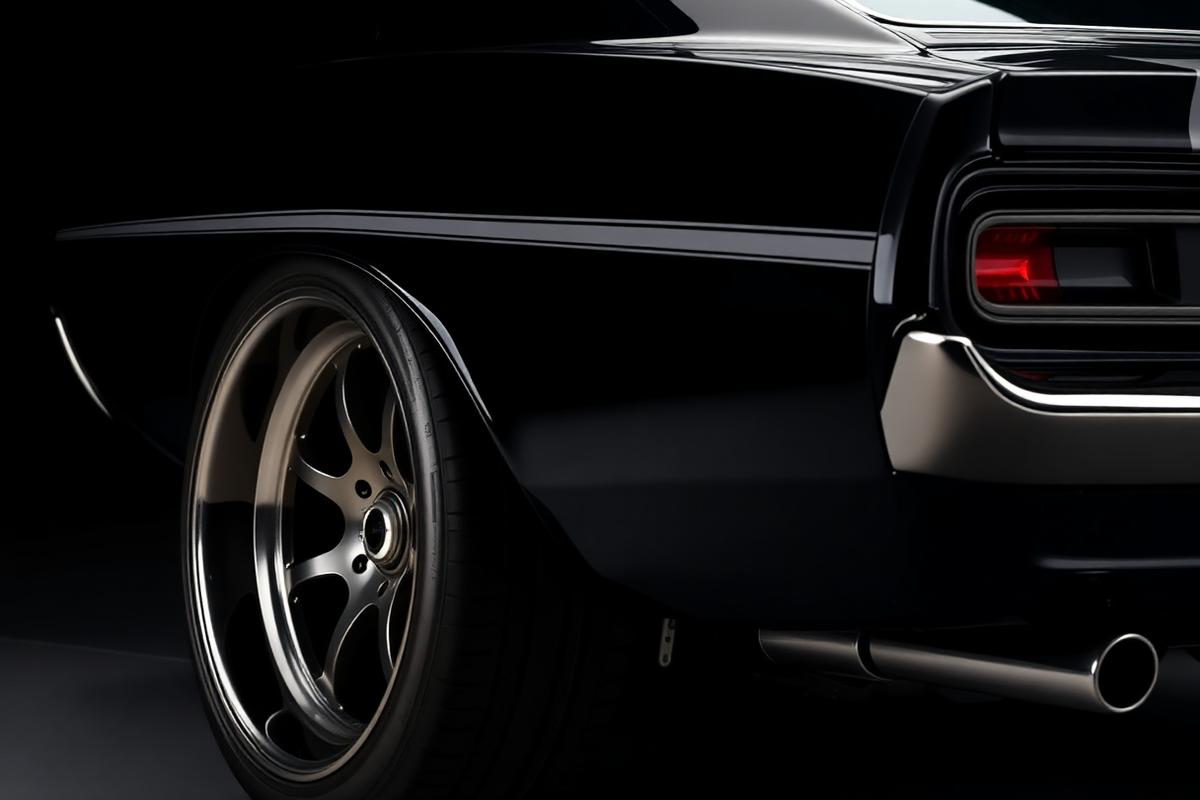 Rear quarter of a matte black muscle car in the shop